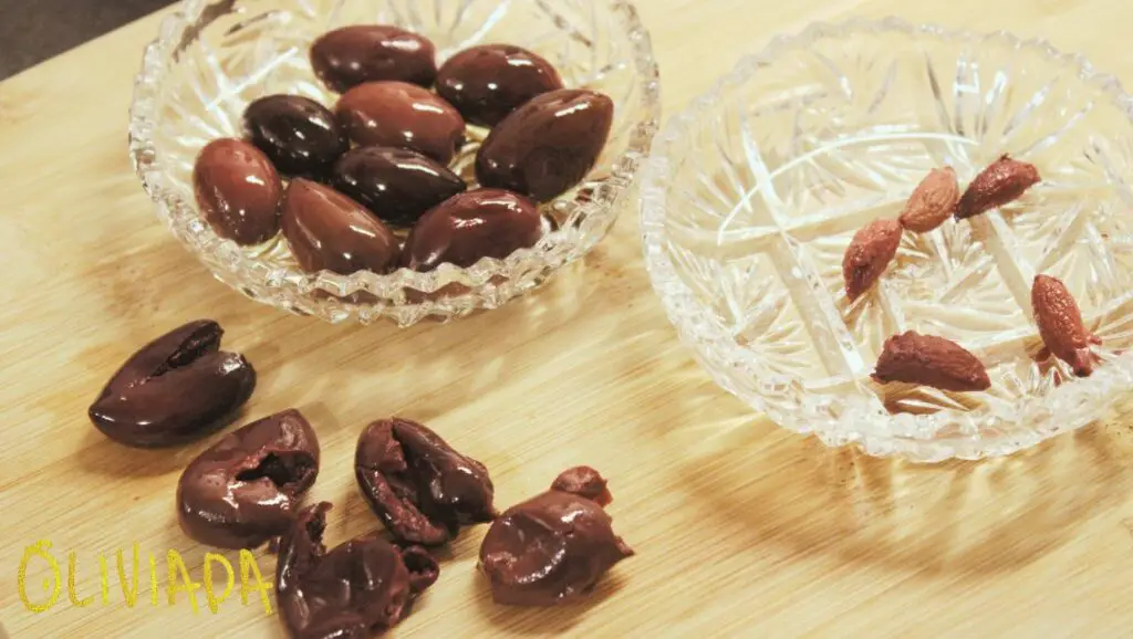 image showcasing dark brown Kalamata olives in the bowl and olive pits can be used for fuel, crafts, skincare and food products